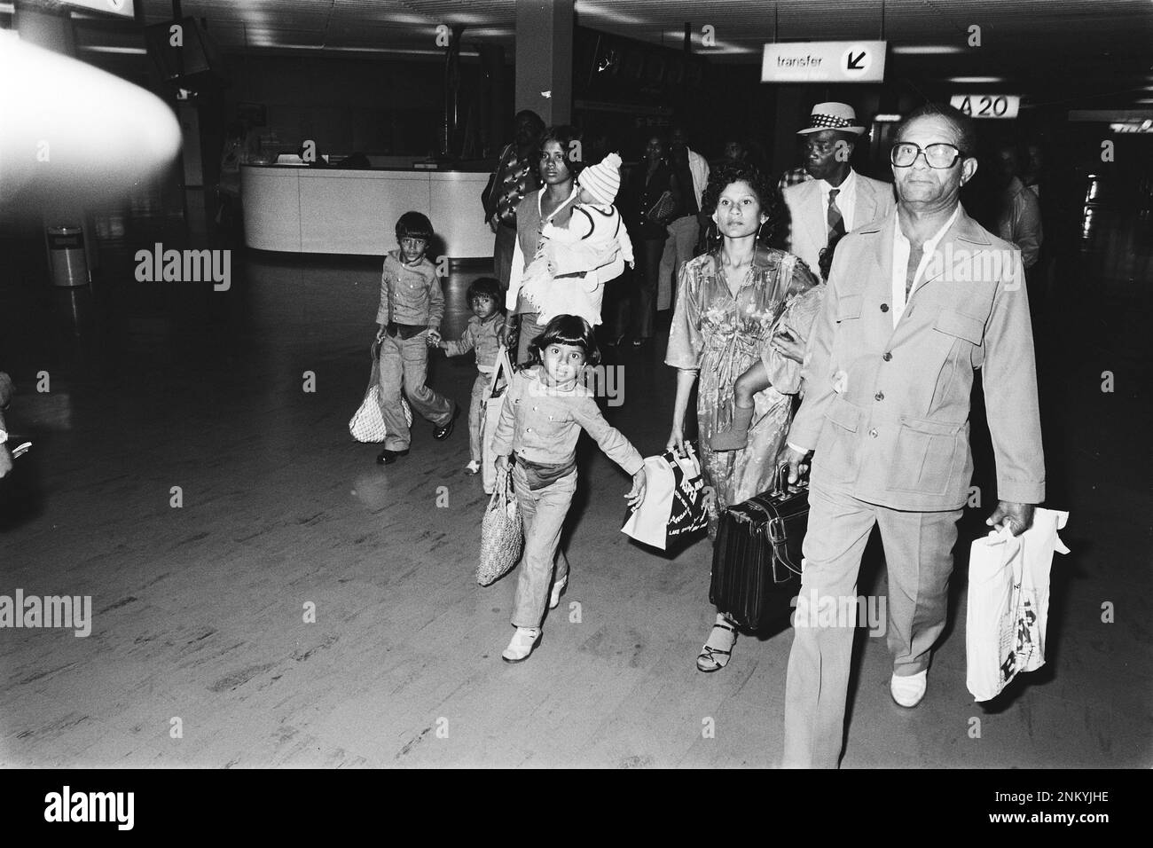 Storia dei Paesi Bassi: La famiglia cammina attraverso il terminal dopo l'arrivo a Schiphol dell'aereo 1st da Paramaribo dopo un colpo di stato militare ca. Febbraio 29, 1980 Foto Stock