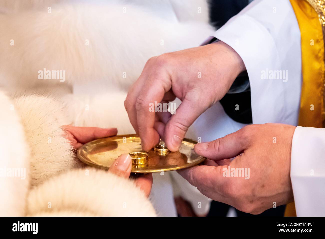 mani, anelli di nozze e voti di matrimonio lo sposo prende l'anello di nozze dal piatto Foto Stock