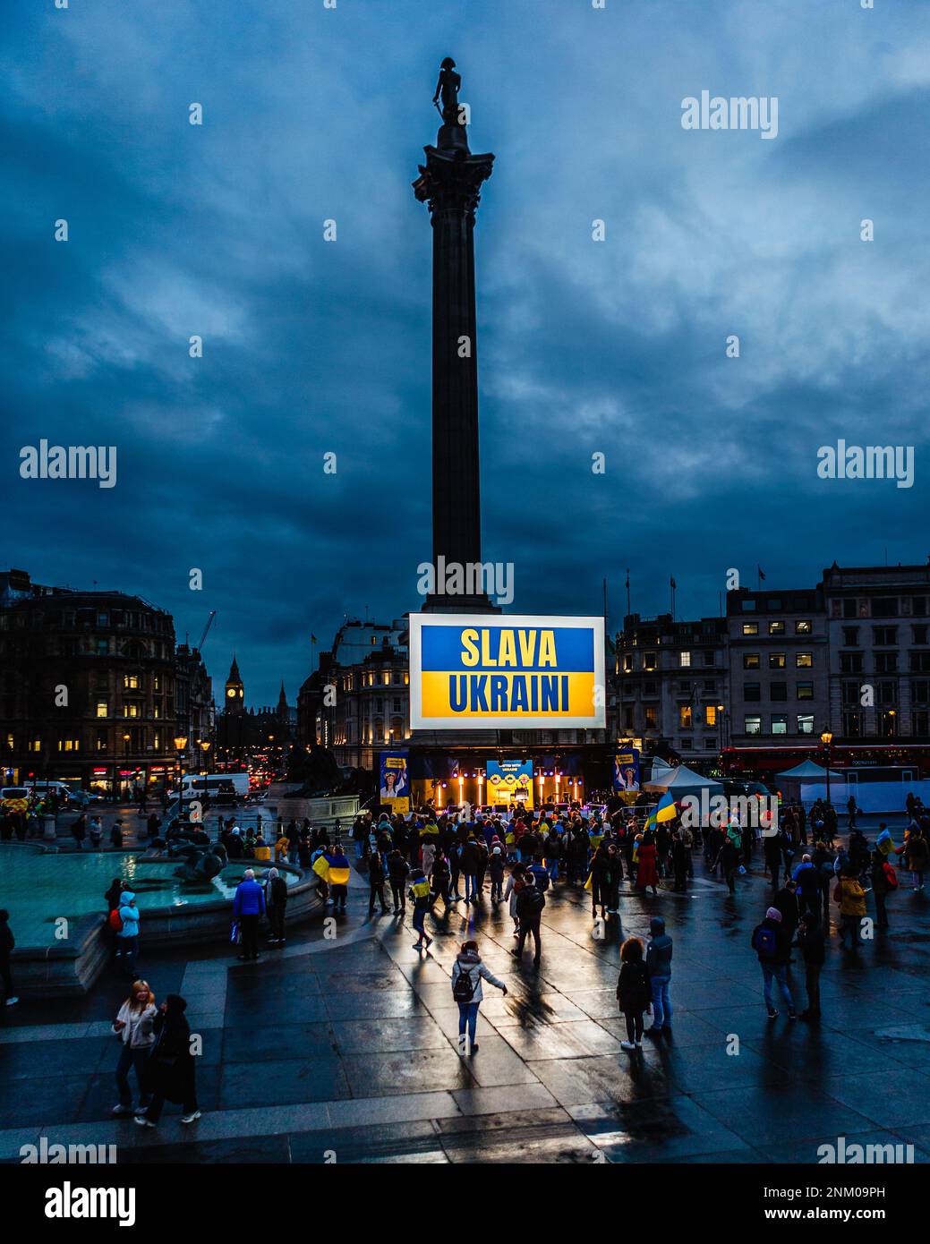 I manifestanti iniziano a riunirsi in una veglia a Trafalgar Square per celebrare il primo anniversario dell'invasione russa dell'Ucraina. Foto Stock