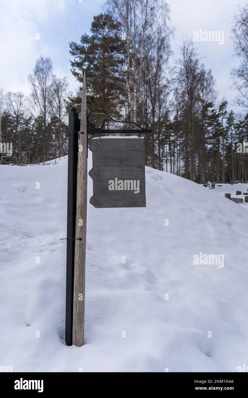 Cartello in legno antico vuoto appeso al palo in inverno Foto Stock