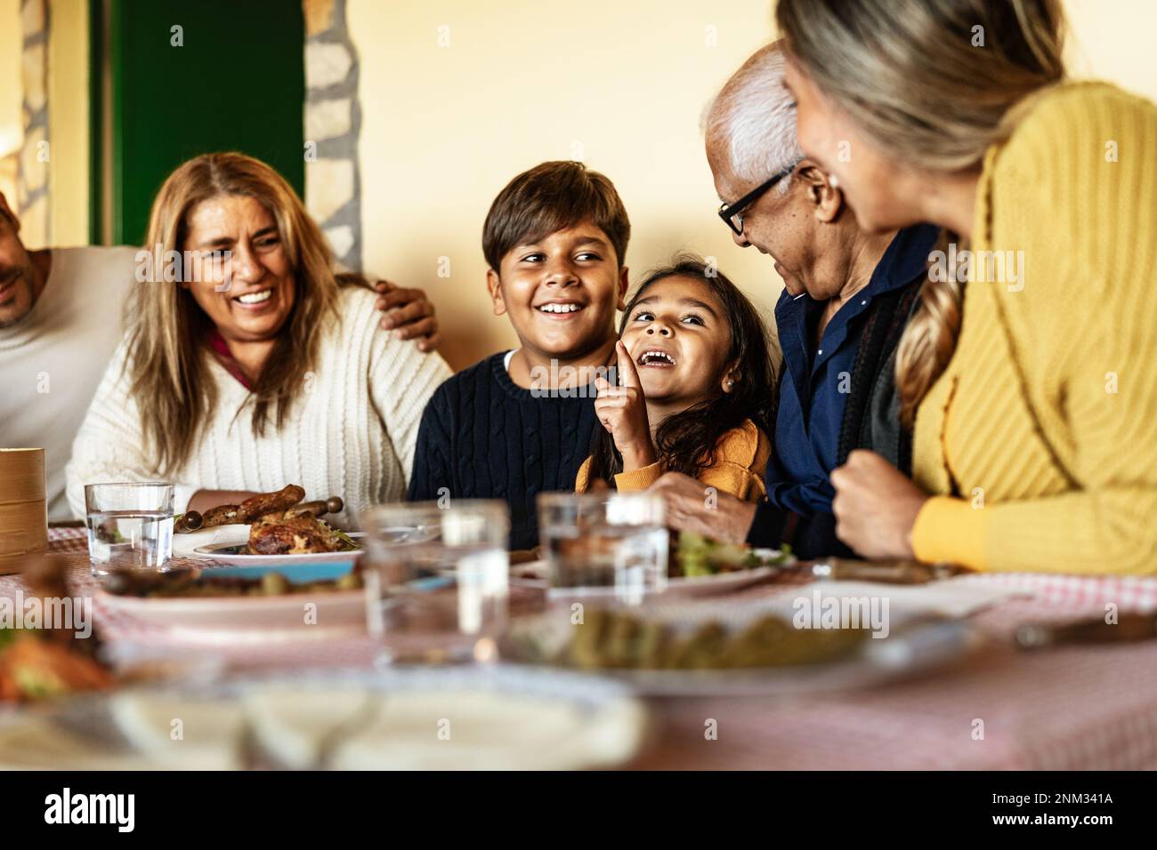 Felice famiglia latina divertirsi a pranzo insieme a casa Foto Stock