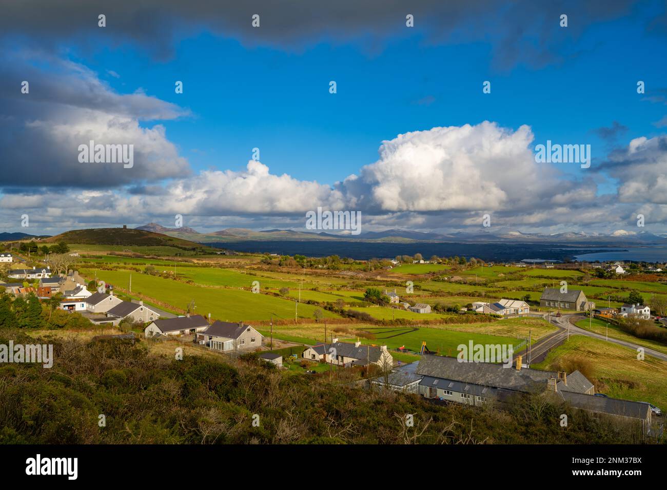 Guardando verso le montagne di snowdonia lungo la penisola di Llyn da Mynytho Galles del Nord Foto Stock