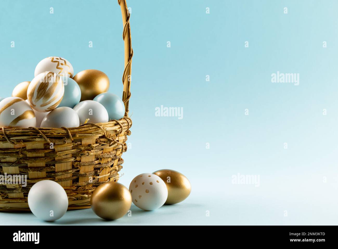 Immagine di uova di pasqua multicolore nel cestino e spazio copia su sfondo blu Foto Stock