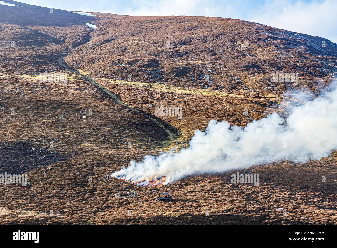 La combustione controllata di brughiera di erica (altalene o muirburn) sulle pendici di Sgor Mor a sud di Braemar, Aberdeenshire, Scozia UK Foto Stock