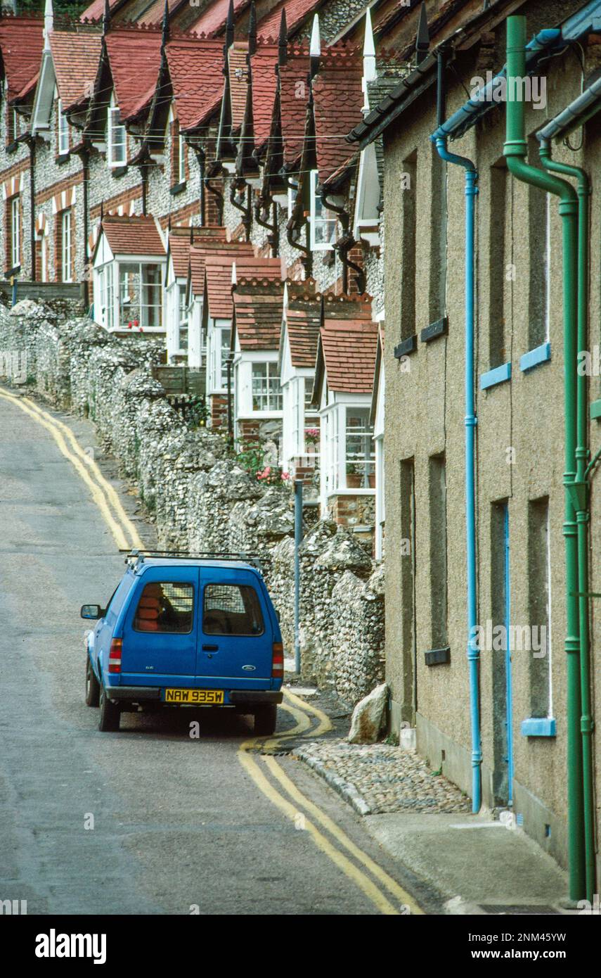 Lone blu auto parcheggiata su strada con case a file strettamente raggruppati con facciate di ciottoli nel sud costiero Inghilterra villaggio Foto Stock