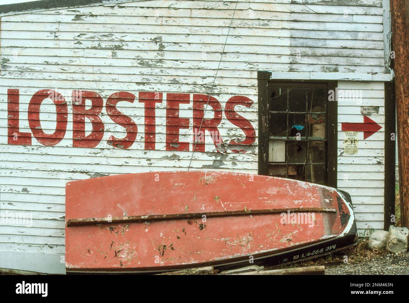 Parete grafica per Lobsters in vendita su clapboard intemperie con skiff in legno rovesciato a York Harbor Maine Foto Stock