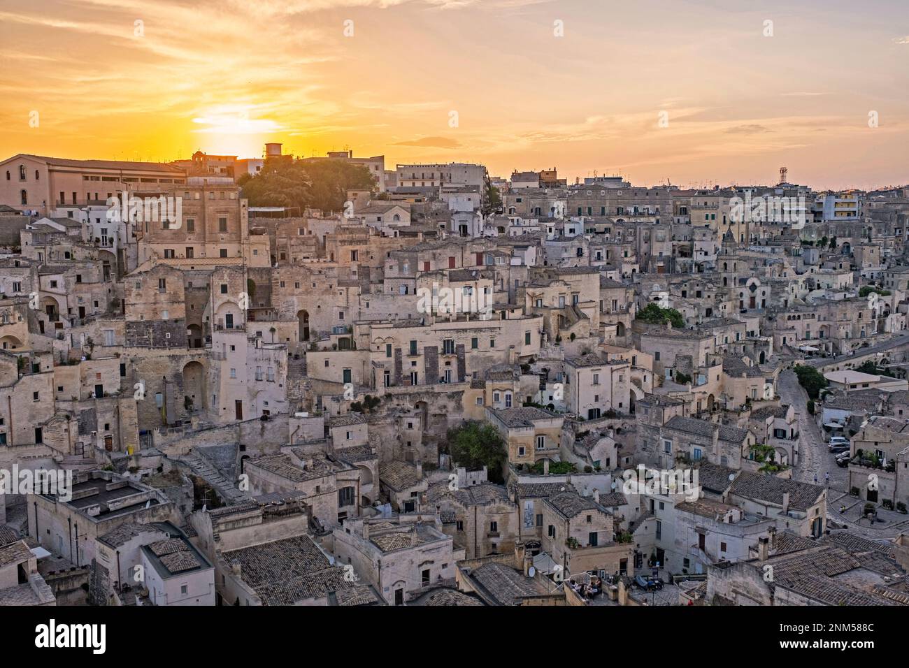 Vista sul complesso dei Sassi di Matera, con le sue abitazioni rupestri al tramonto, nell'antica città di Matera, capitale della Basilicata, Italia meridionale Foto Stock