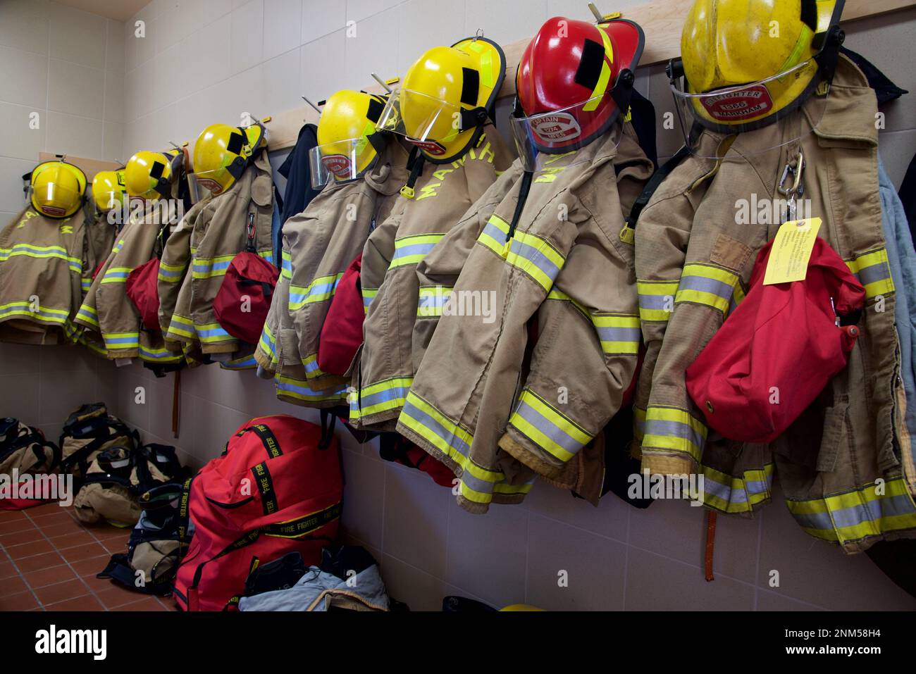Primo piano dei vestiti dei vigili del fuoco e del casco su un appendiabiti Foto Stock