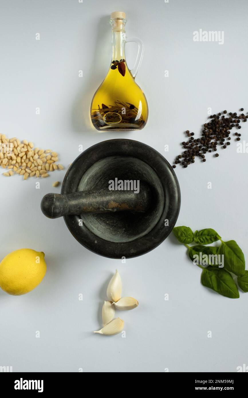 Creatività culinaria: Pinoli, pepe, basilico e aglio convergono in olio d'oliva, un capolavoro astratto di sapori che stuzzicano le papille gustative. Foto Stock