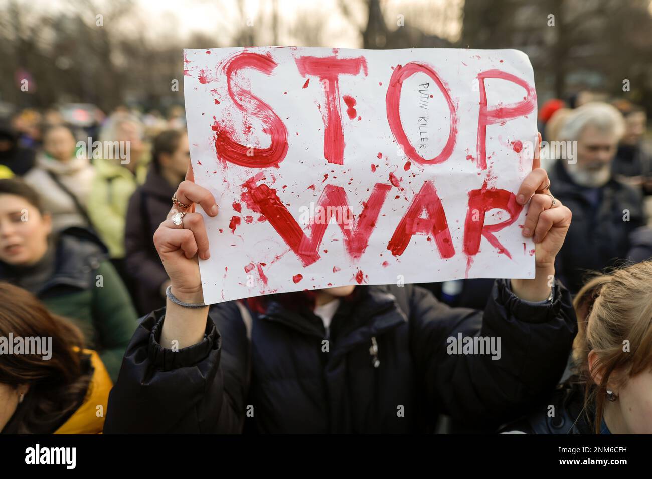 Bucarest, Romania - 24 febbraio 2023: Immagine poco profonda di campo (fuoco selettivo) con la mano di una donna che detiene una bandiera anti-guerra in Ucraina Foto Stock