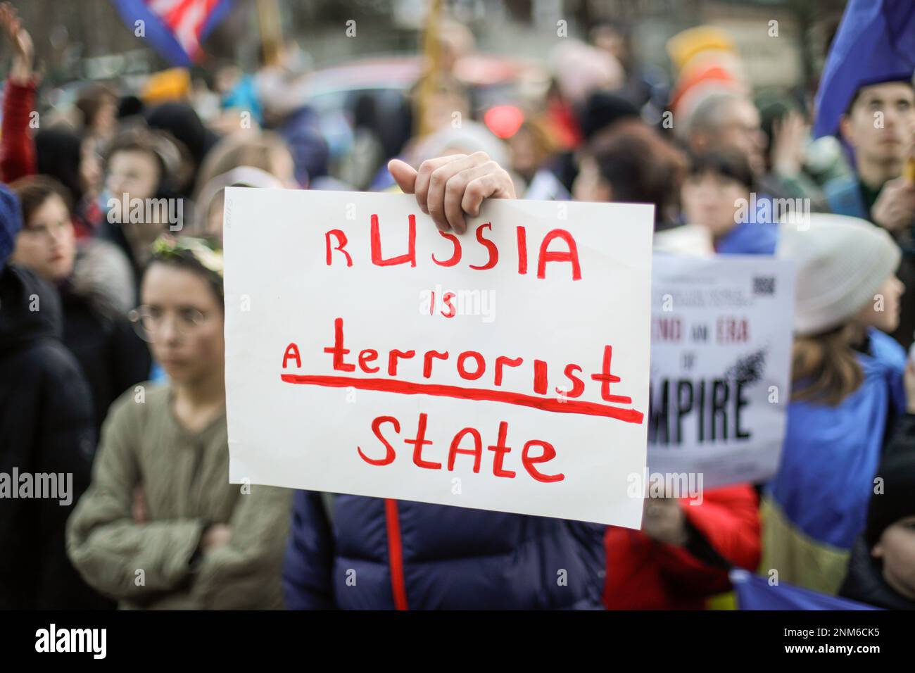Bucarest, Romania - 24 febbraio 2023: Profondità di campo poco profonda (fuoco selettivo) immagine con la mano di un uomo in possesso di una anti guerra in Ucraina banner du Foto Stock