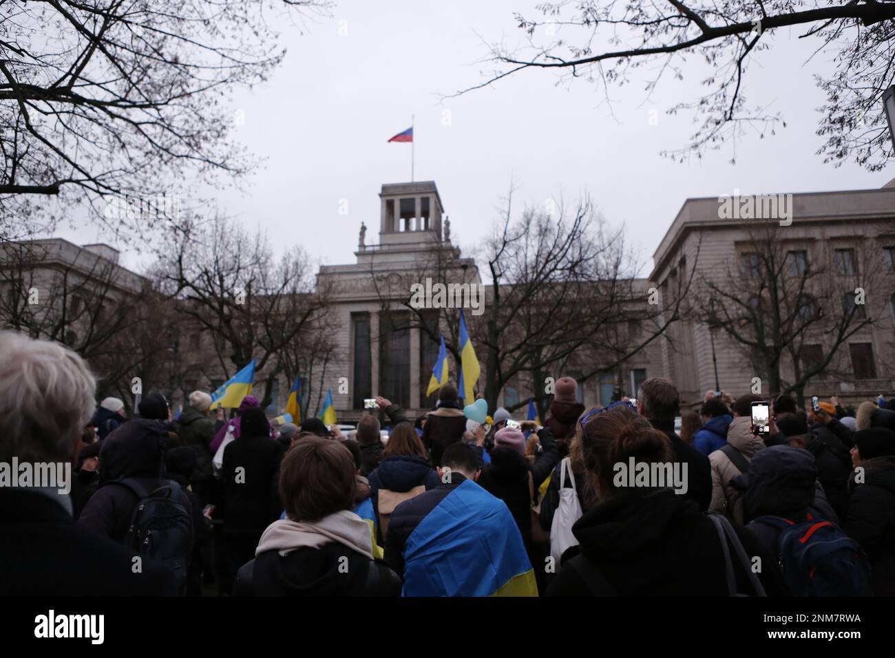 Germania, Berlino, 02/24/2023. La gente si mostra davanti all'ambasciata russa a Berlino-Mitte per commemorare l'anniversario dell'attacco russo contro l'Ucraina. Il carro armato T-72 distrutto si dice che si trovi di fronte all'edificio Unter Den Linden per alcuni giorni come memoriale contro la guerra. Foto Stock