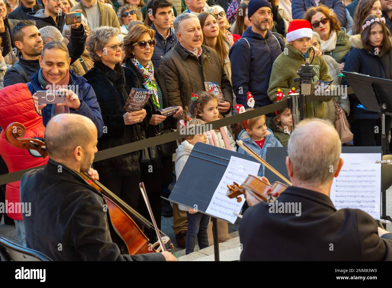 Granada, Spagna; 18 dicembre 2022: Alcuni musicisti e il direttore della Granada Symphony Orchestra suonano un carol di Natale per strada Foto Stock