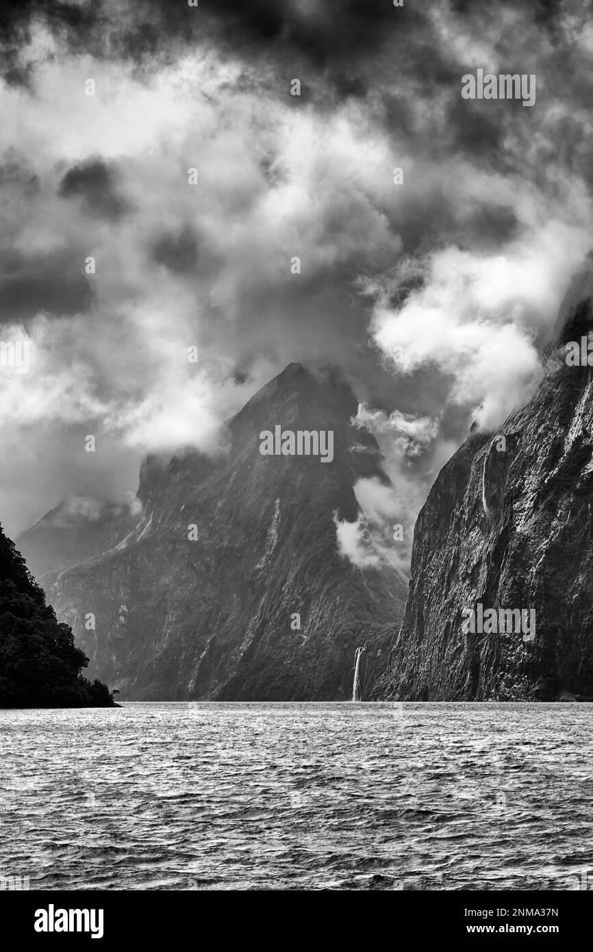 Milford Sound fiordo della Nuova Zelanda con spettacolari vette di montagna e cascata in condizioni di pioggia drammatica. Foto Stock