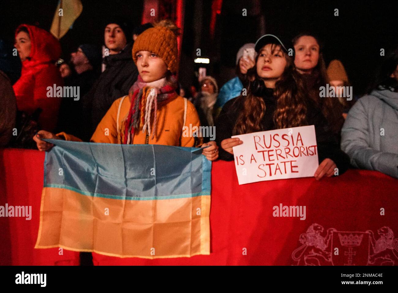 Danzica, Polonia. 24th Feb, 2023. Persone che detengono bandiere ucraine e polacche in occasione del Rally europeo di solidarietà anti-guerra con l'Ucraina nel primo anniversario dell'attacco russo contro l'Ucraina a Plac Solidarnosci sono viste a Danzica, Polonia il 24 febbraio 2023 si vede una donna Ucraina che ha una bandiera che parla la Russia è uno Stato terrorista. (Foto di Michal Fludra/NurPhoto) Credit: NurPhoto SRL/Alamy Live News Foto Stock