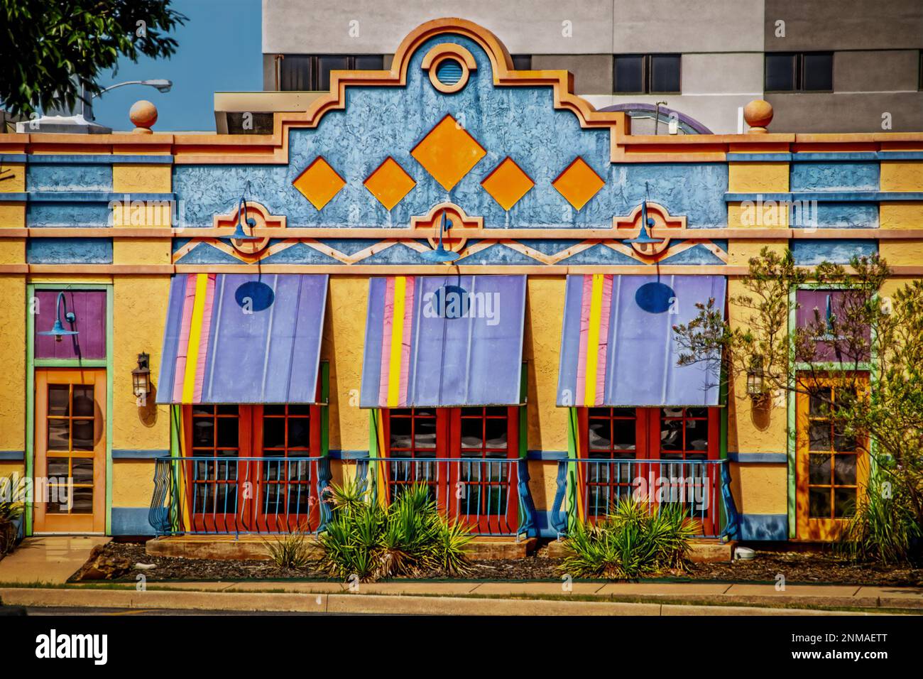 Ristorante messicano dai colori luminosi e decorato con tende e moderno edificio di uffici sullo sfondo Foto Stock