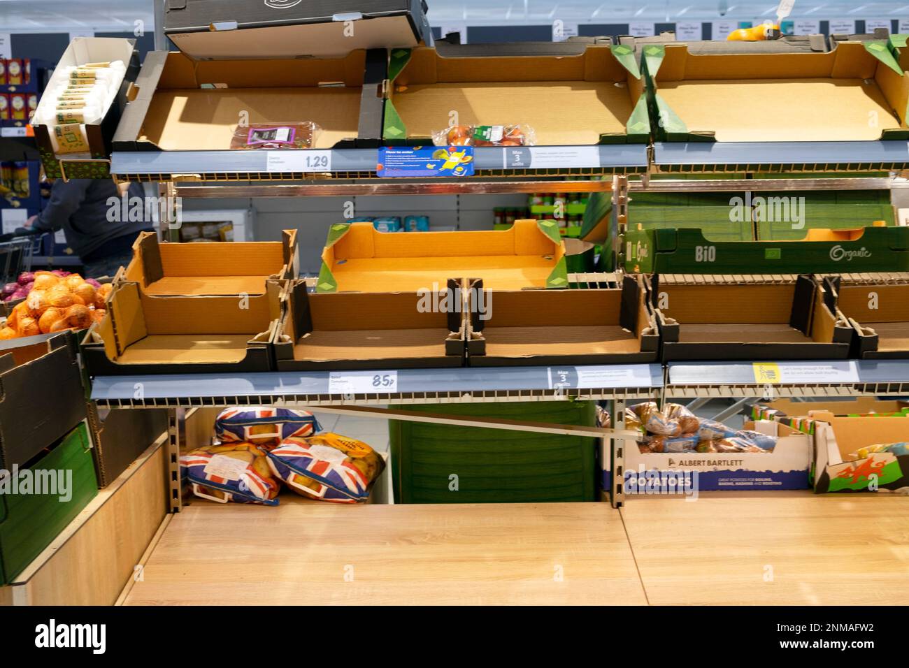 Scaffali vuoti scatole casse con pochi sacchetti di plastica rimasti di patate britanniche gallesi sullo scaffale del supermercato Lidl 24 febbraio 2023 Galles UK KATHY DEWITT Foto Stock