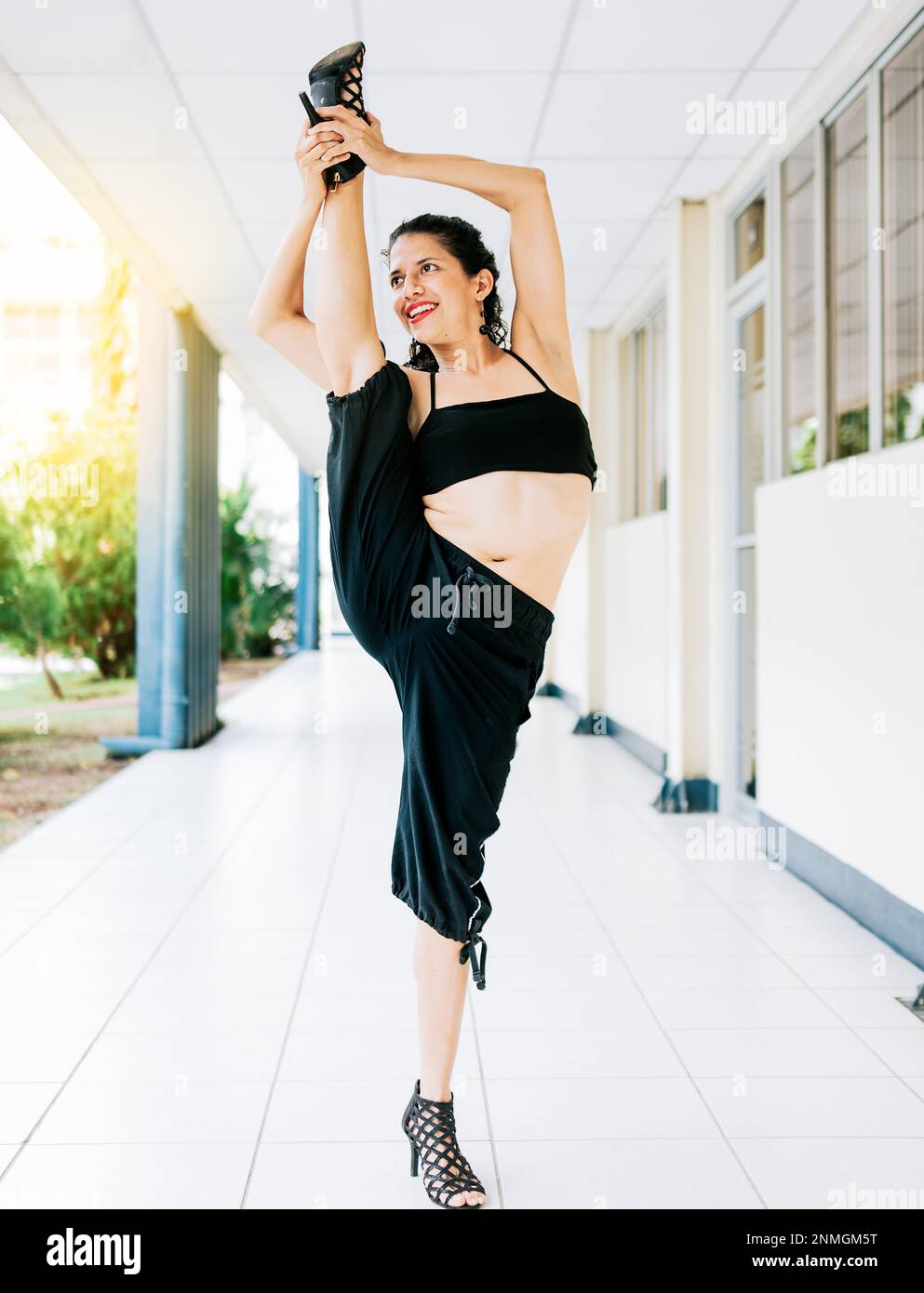 Donna danzatrice in tacchi facendo yoga flessibilità. Dance artista donna fare acrobazie e flessibilità in tacchi. Concetto artistico di ginnastica, Danza Foto Stock