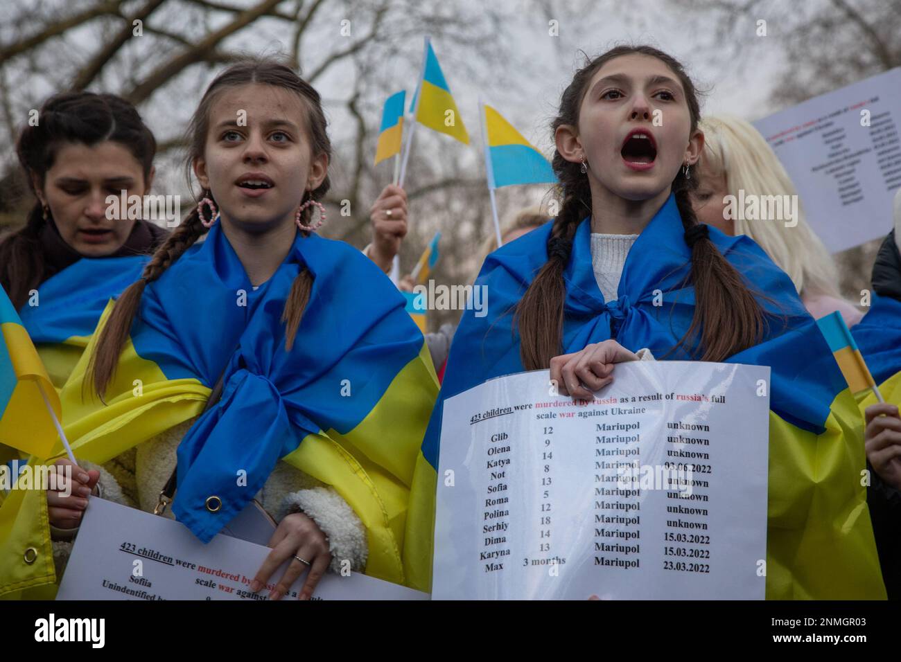 Londra, Regno Unito. 24th Feb 2023. Londra, Regno Unito. I bambini guidano la marcia per protestare contro l'Ambasciata Russa a seguito di un servizio commemorativo ecumenico presso la Statua di San Volodymyr in Holland Park nel primo anniversario dell'invasione russa dell'Ucraina. Portano i nomi dei 423 bambini ucraini che hanno perso la vita durante questa guerra. Credit: Kiki Streitberger /Alamy Live News Foto Stock