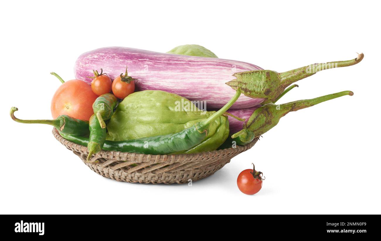 verdure biologiche varie su un cestino o contenitore, melanzane, pomodori, peperoncini verdi e chayote isolato su sfondo bianco Foto Stock