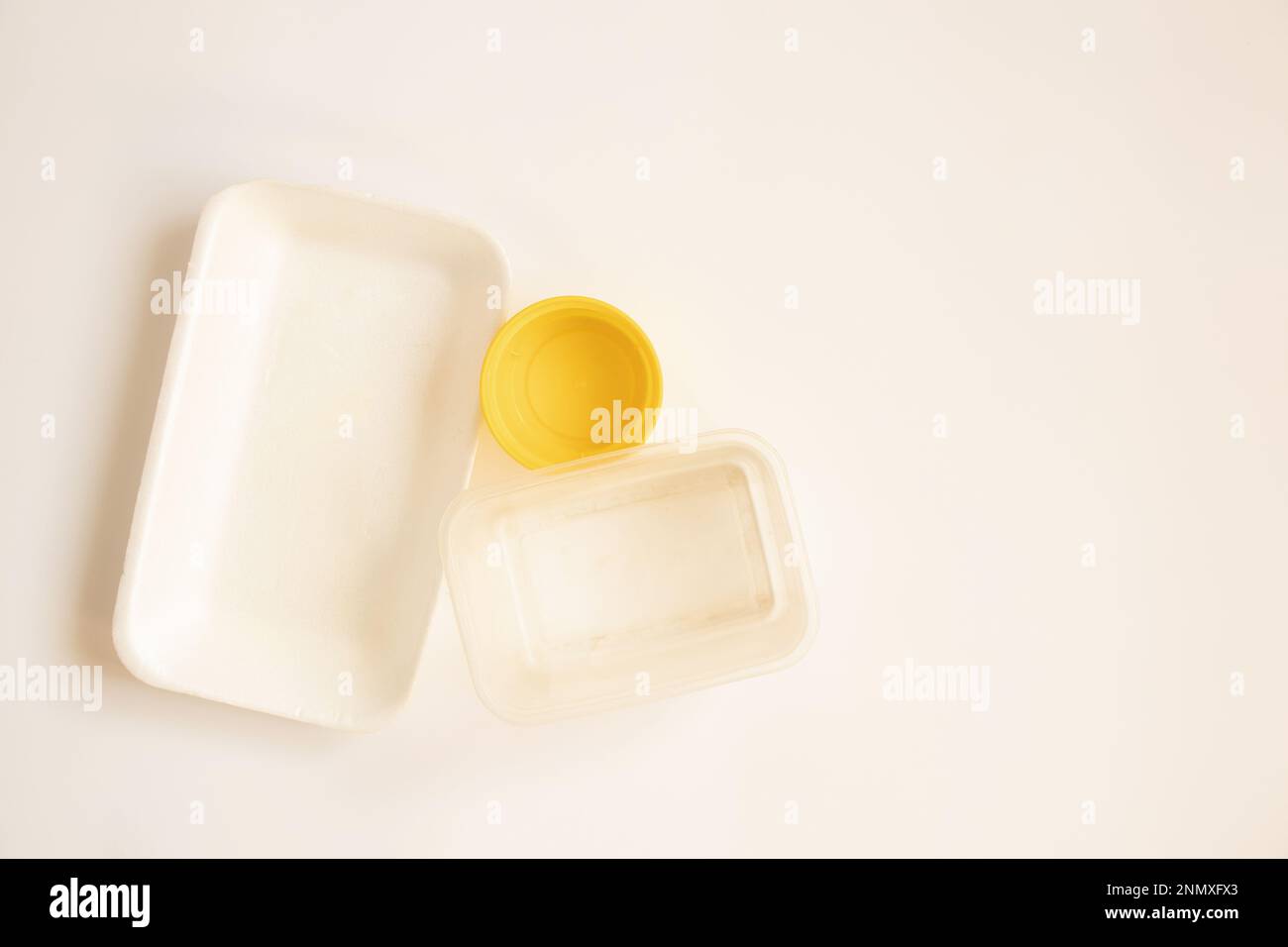 Diversi vecchi imballaggi in plastica si trovano su uno sfondo bianco, contenitori per alimenti Foto Stock