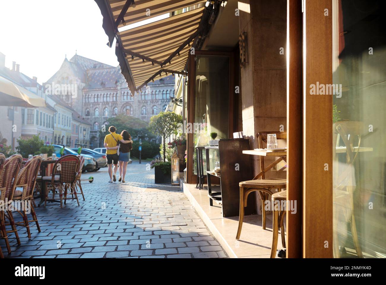 Street cafe ombrellone e sedie nella città vecchia, coppia che abbraccia camminare Foto Stock