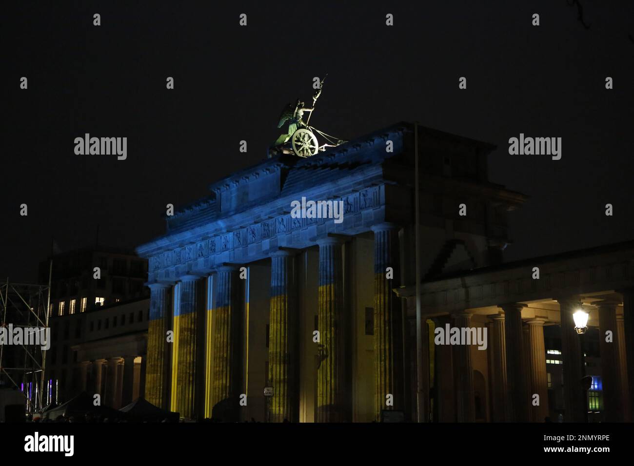 Germania, Berlino, 02/24/2023. Brandenburger Tor brilla nei colori dell'Ucraina in occasione dell'anniversario dell'attacco russo contro l'Ucraina al Platz des 18. März (Piazza 18 marzo). Foto Stock