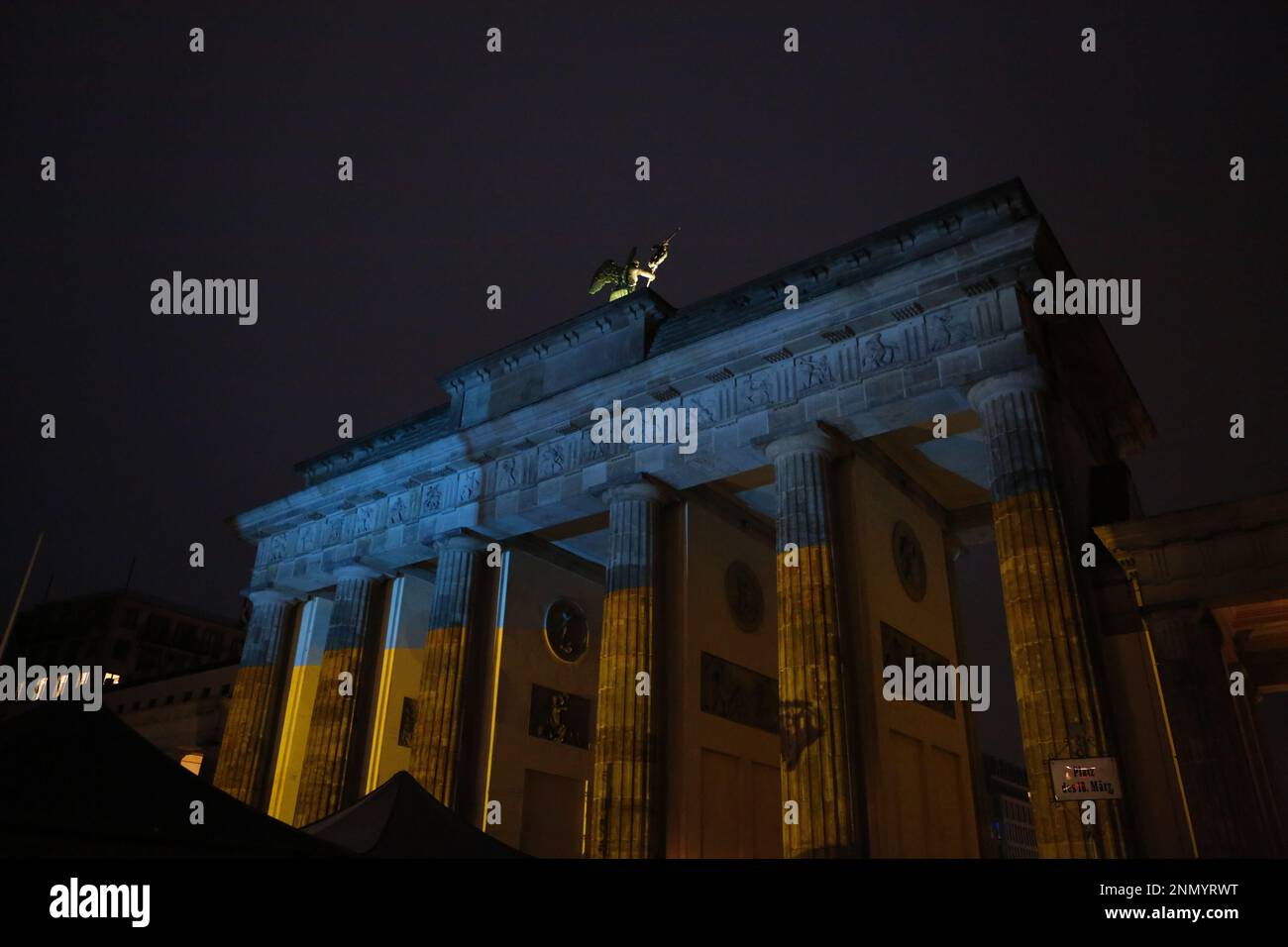 Germania, Berlino, 02/24/2023. Brandenburger Tor brilla nei colori dell'Ucraina in occasione dell'anniversario dell'attacco russo contro l'Ucraina al Platz des 18. März (Piazza 18 marzo). Foto Stock