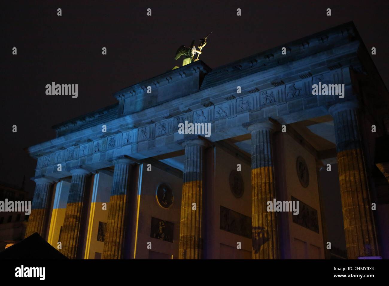 Germania, Berlino, 02/24/2023. Brandenburger Tor brilla nei colori dell'Ucraina in occasione dell'anniversario dell'attacco russo contro l'Ucraina al Platz des 18. März (Piazza 18 marzo). Foto Stock