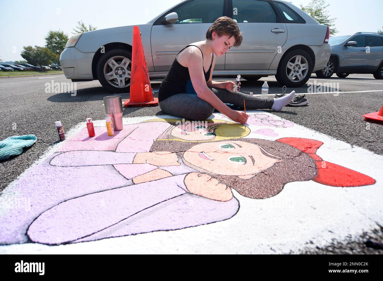 Heritage High School senior Emma Delaney, 17, paints a senior parking space at the school on Thursday, July 29, 2021. The space, which Delaney is painting in a Studio Ghibli anime style, is for a friend. (Matt Hamilton/Chattanooga Times Free Press via AP) Foto Stock