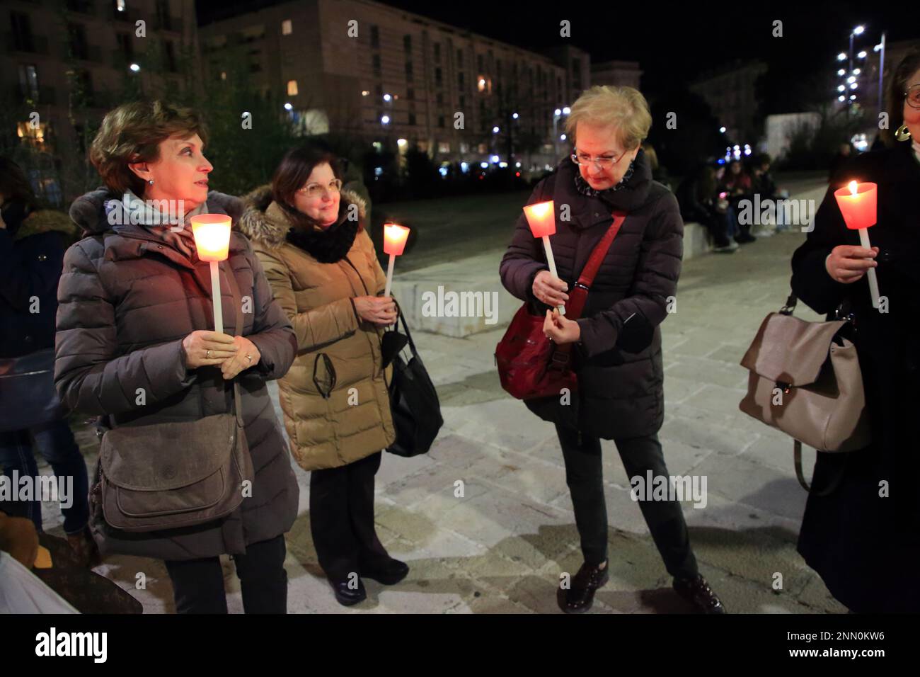 Persone con bandiere di pace , segni di protesta e torce partecipano a un incontro e marcia per chiedere la fine della guerra in Ucraina. Foto Stock