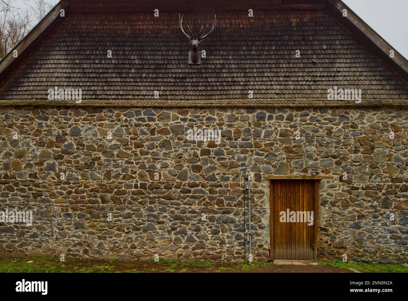 Facciata in pietra di una casa di un forestiere con un trofeo di caccia di cervi in cima alla casa fronte (posizione: Parco faunistico 'Alte Fasanerie', Hanau) Foto Stock