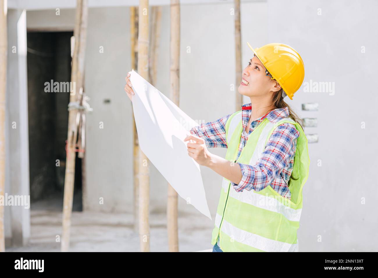 Donna asiatica ingegnere lavoratore lavoro in cantiere. Smart builder architetto femmina in suite di sicurezza di lavoro. Foto Stock
