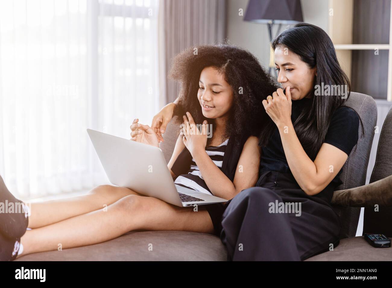 Guida dei genitori insegnare e prendersi cura dei bambini ragazza teen guardando contenuti multimediali Internet sul computer portatile insieme a casa. Foto Stock