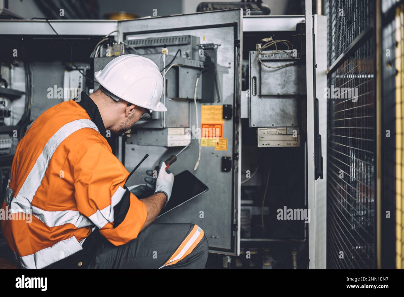 ingegnere elettrico maschio lavoro pericoloso riparazione servizio armadio elettrico ad alta tensione. lavoratore riparare il problema di sovratensione elettrica problema nel settore fatto Foto Stock