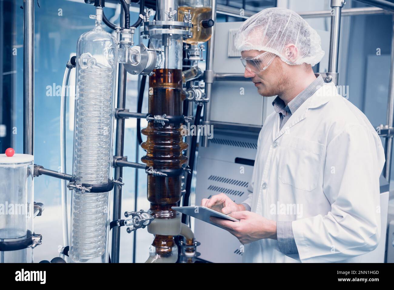 Uomo scienziato che lavora Cannabis estrazione di olio CBD per laboratorio di scienza medica. Estrazione olio di canapa Distillation Machine Thin Film in Laboratory Plants Pro Foto Stock