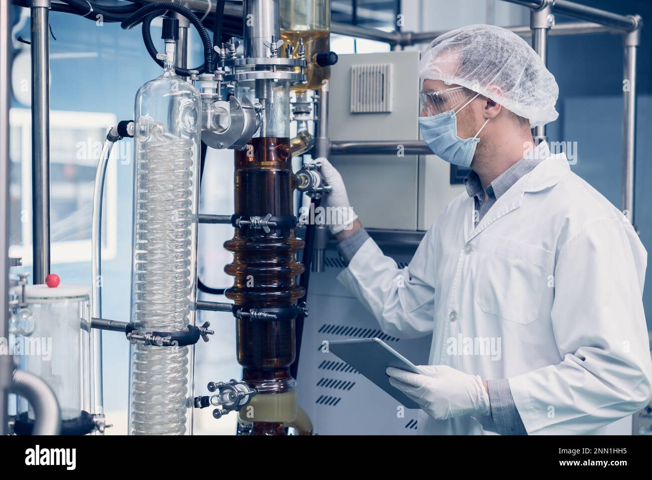 Uomo scienziato che lavora Cannabis estrazione di olio CBD per laboratorio di scienza medica. Estrazione olio di canapa Distillation Machine Thin Film in Laboratory Plants Pro Foto Stock