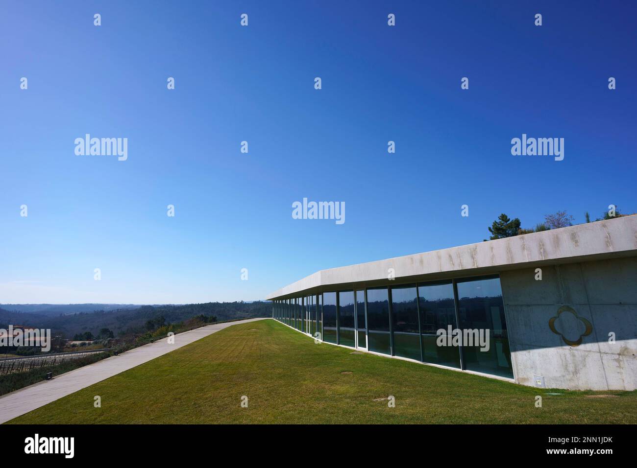 Moderno edificio contemporaneo in cemento con grande superficie vetrata che guarda ad una collina Foto Stock