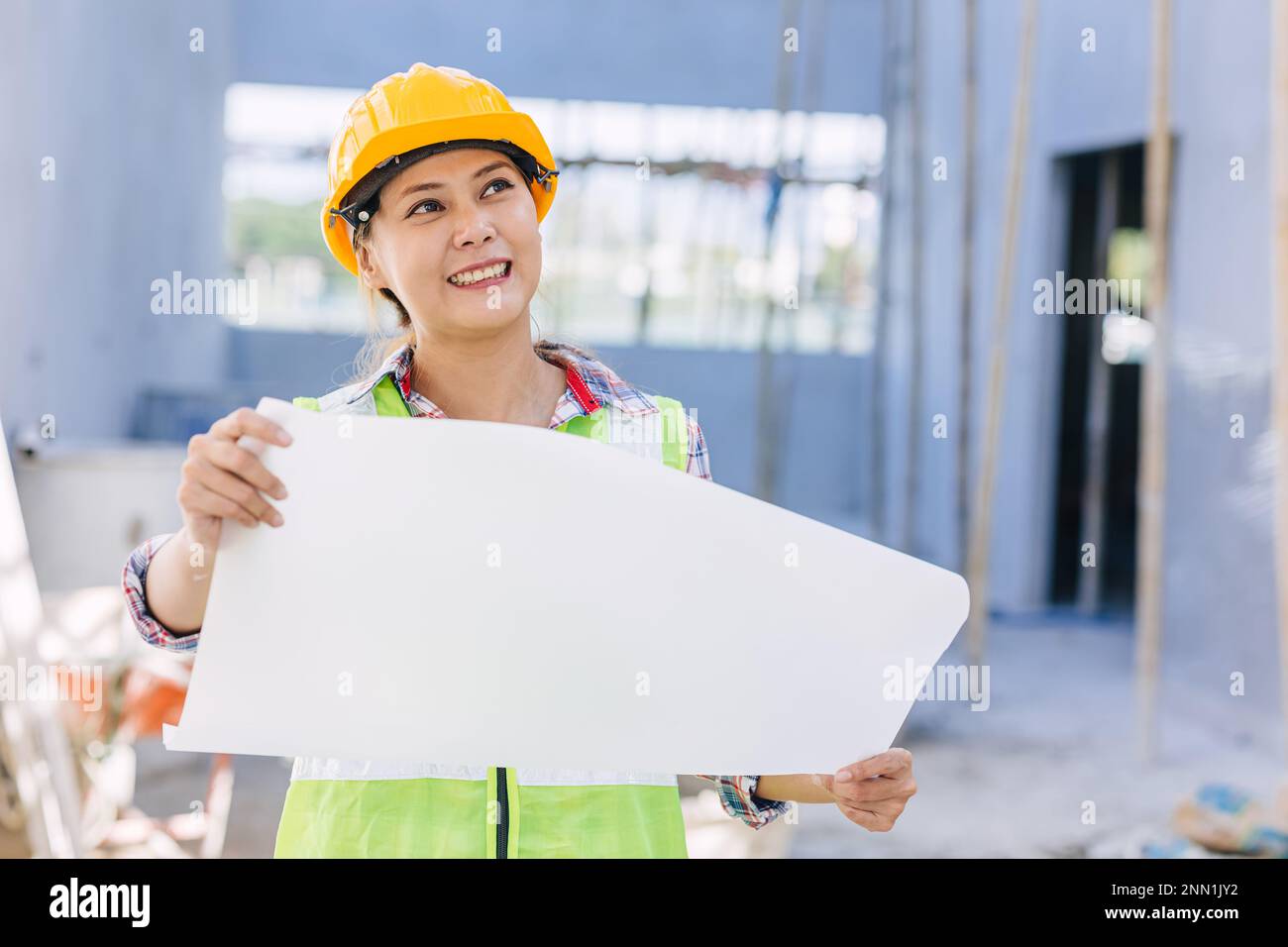 Donna asiatica ingegnere lavoratore lavoro in cantiere. Smart builder architetto femmina in suite di sicurezza di lavoro. Foto Stock