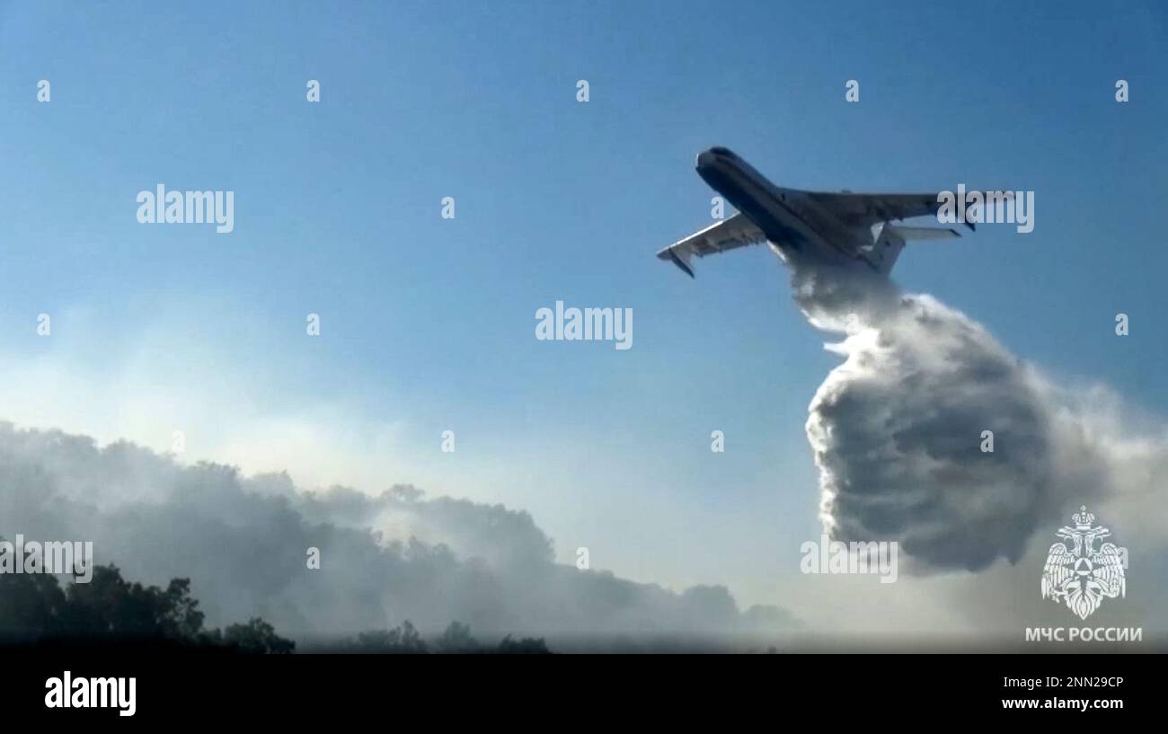In this photo taken from video released by Russian Emergency Situations Ministry press service, a Russian Emergency Ministry's Beriev multipurpose amphibious aircraft Be-200 drops water during extinguishing a forest fire in the republic of Sakha also knows as Yakutia, Russia Far East, Sunday, July 18, 2021. Russia has been plagued by widespread forest fires, blamed on unusually high temperatures and the neglect of fire safety rules, with Sakha-Yakutia in northeastern Siberia being the worst affected region lately. (Russian Emergency Situations Ministry press service via AP) Foto Stock