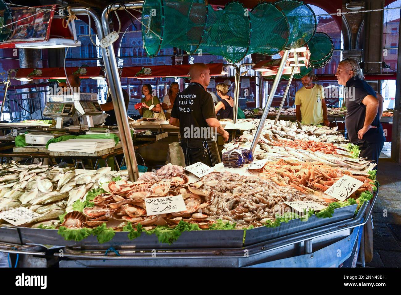 Le persone che acquistano il pescato del giorno sotto la Loggia del mercato ittico nel sestiere di San Polo, Rialto mercato, Venezia, Veneto, Italia Foto Stock