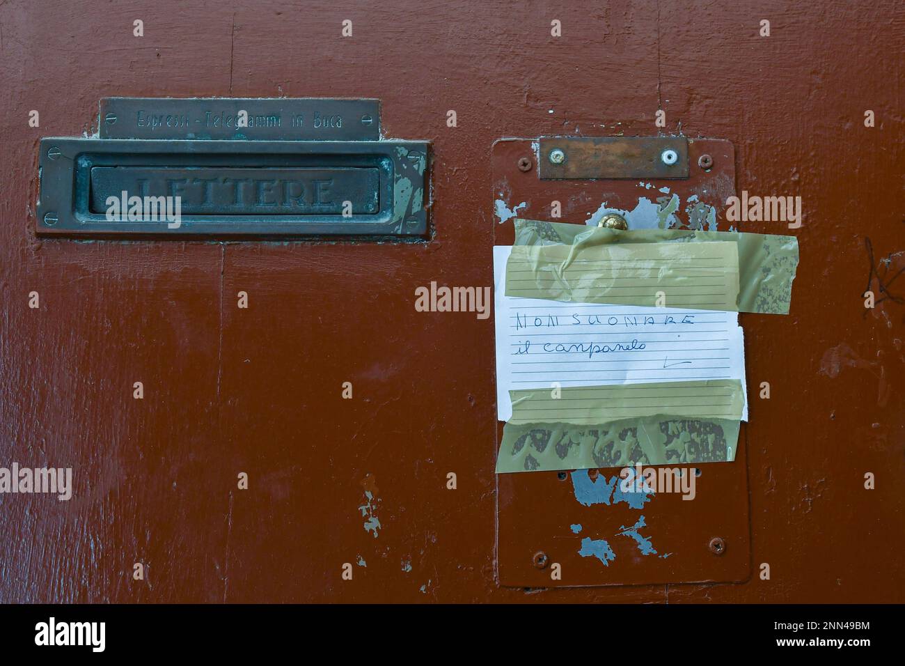 Vecchia porta con un pezzo di carta attaccato con nastro adesivo che dice: 'Non suonare la campana' in un italiano non grammaticale, Venezia, Veneto, Italia Foto Stock