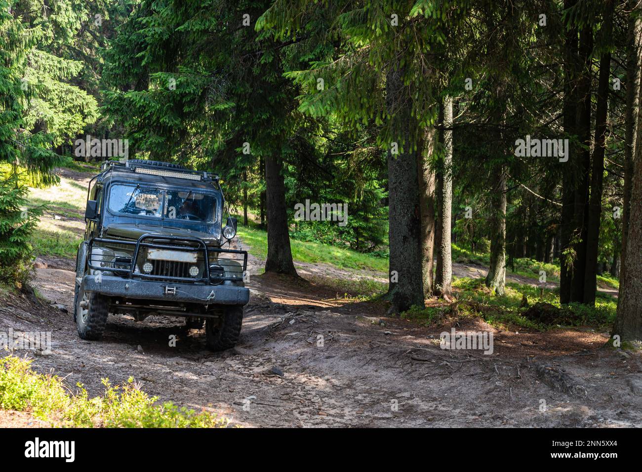 Vecchio SUV 4x4 vintage retro su una strada sterrata di ghiaia in estate. Fuoristrada auto montagna safari avventura natura viaggio concetto di viaggio. Foto Stock