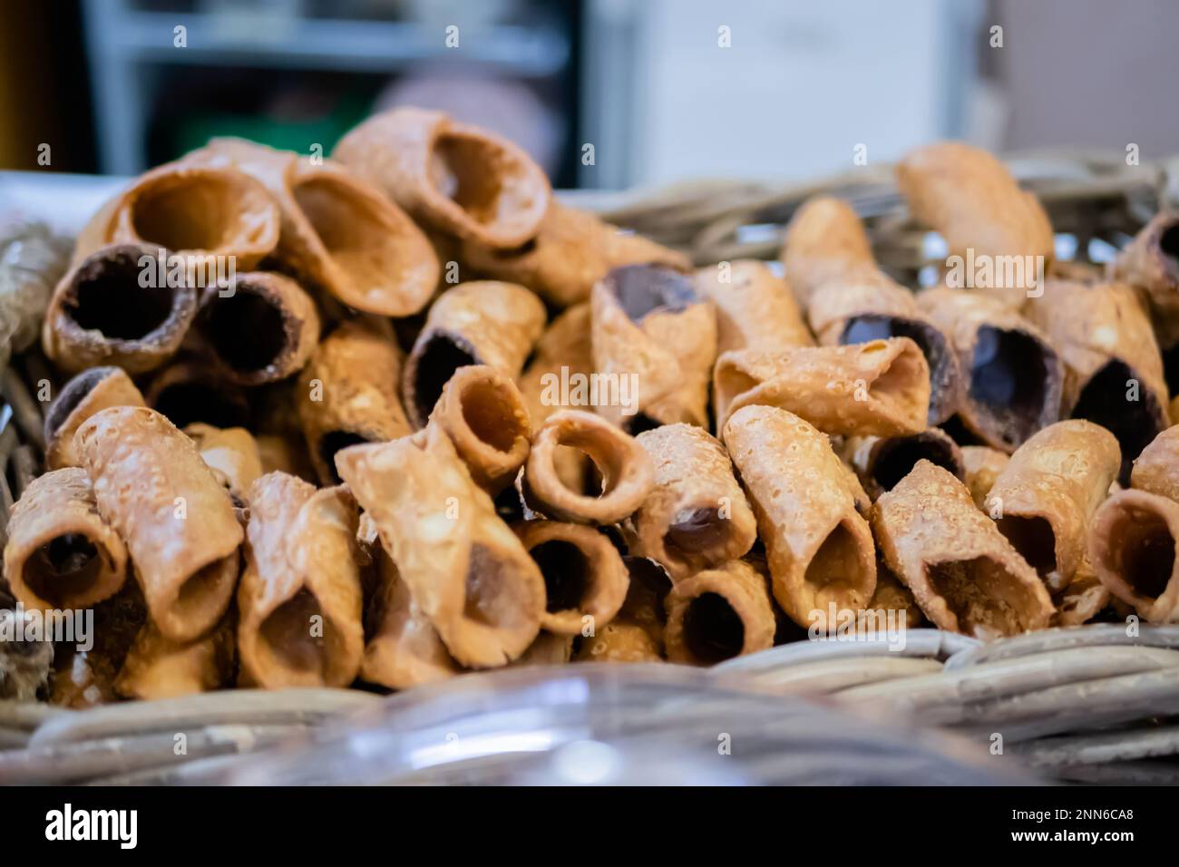 Dolci cannoli fritti vuoti nel cestino al banco del mercato alimentare Foto Stock