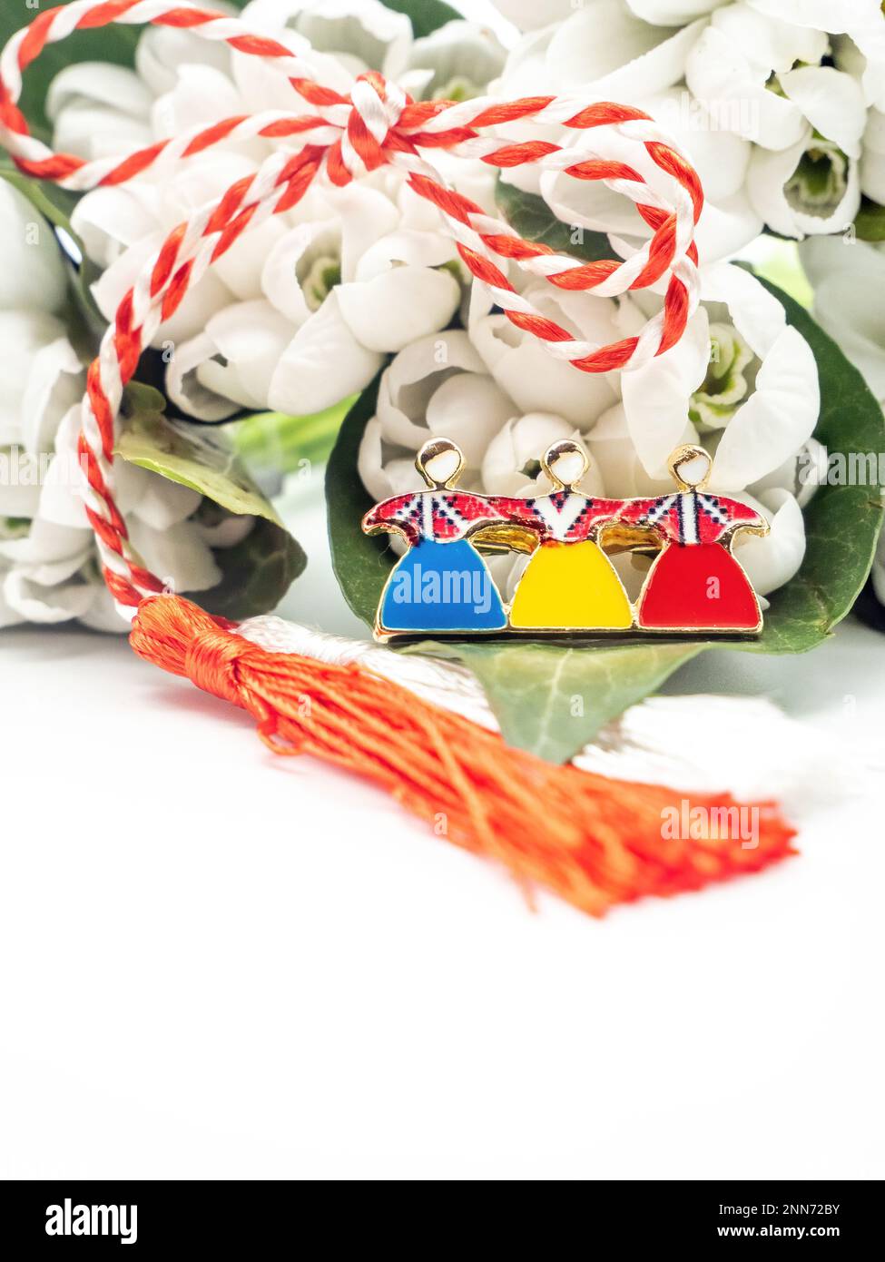 Bouquet di gocce di neve e corde bianche rosse e spilla tricolore su sfondo bianco, 1st marzo festa, Martisor Foto Stock