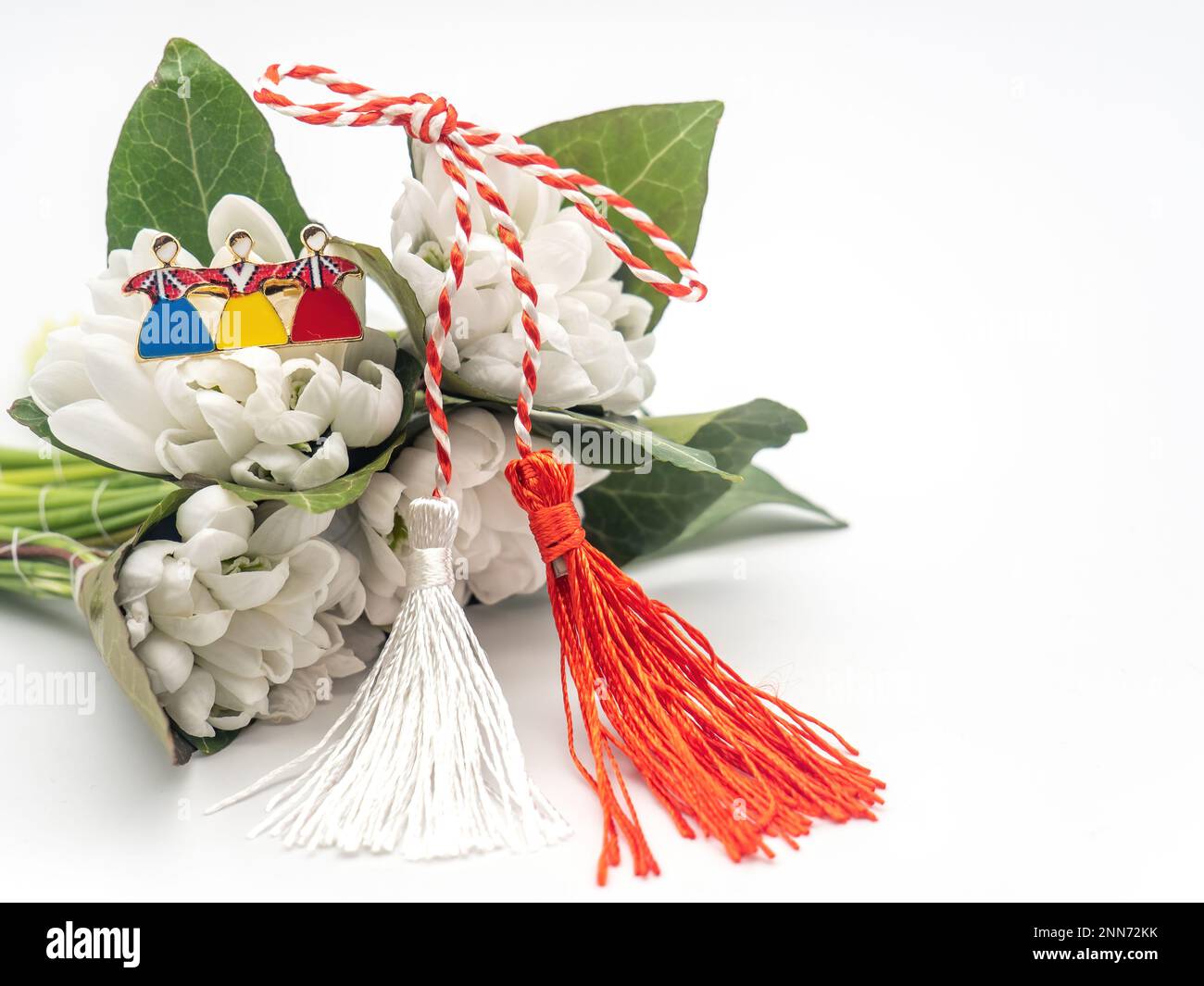 Bouquet di gocce di neve e corde bianche rosse e spilla tricolore su sfondo bianco, 1st marzo festa, Martisor Foto Stock