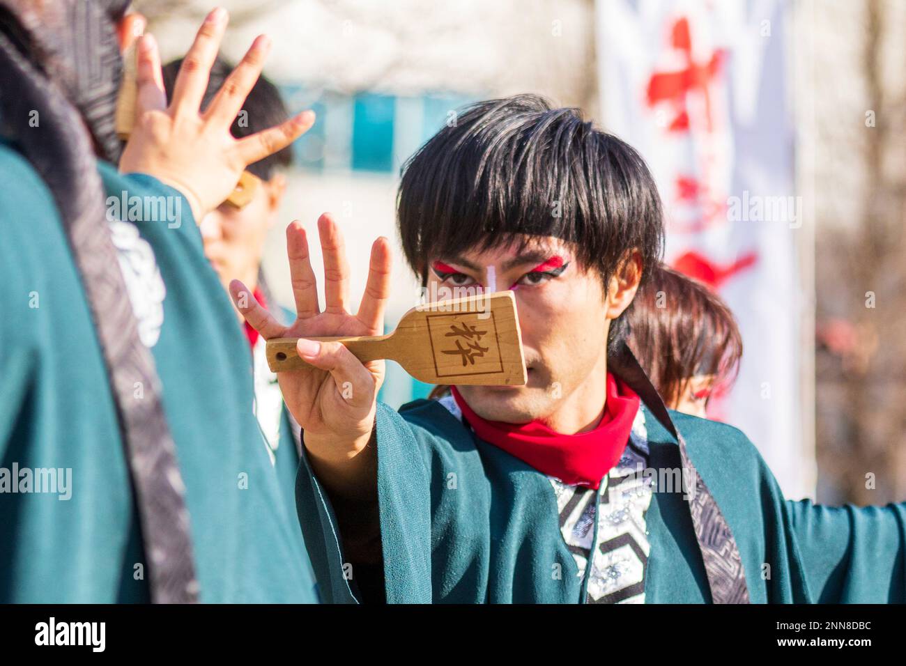 Primo piano, giovane giapponese Yosakoi ballerino e tenendo naruko, clapper, al festival Kyusyu Gassai a Kumamoto. Focus sul naruko. Foto Stock