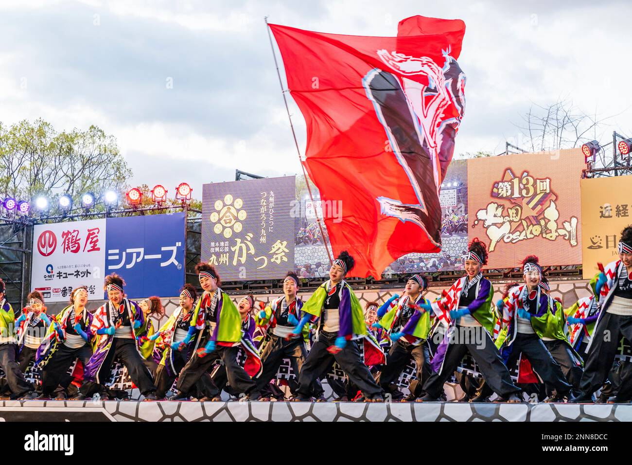 Squadra giapponese di danzatrici Yosakoi ballare e cantare, indossando colorato Yokata sul palco all'aperto al festival Kyusyu Gassai a Kumamoto, sera. Foto Stock