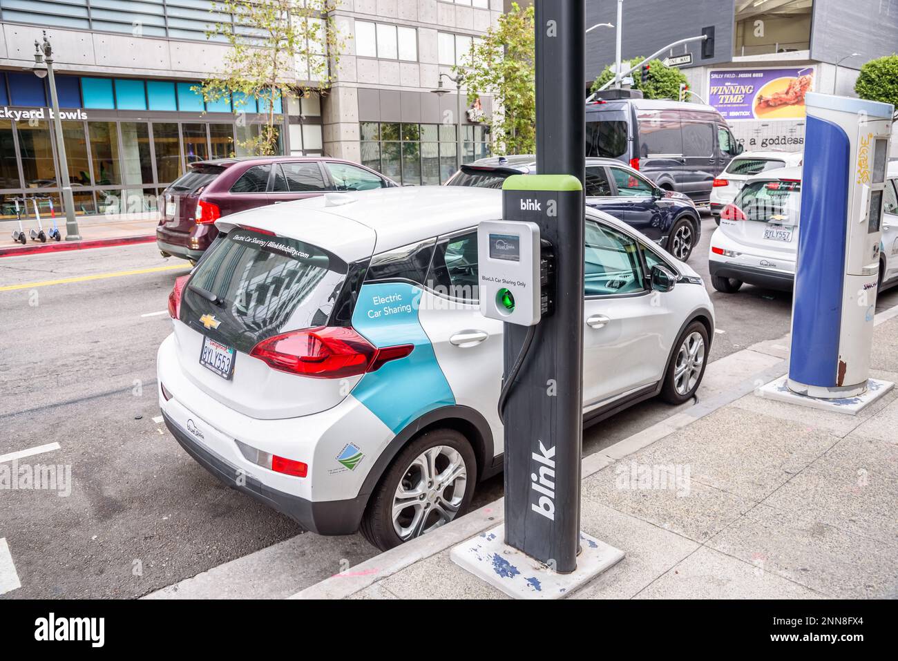 BlueLA Blink sistema di condivisione della mobilità auto elettriche parcheggiate in una posizione di condivisione auto lungo una strada trafficata nel centro di Los Angeles Foto Stock