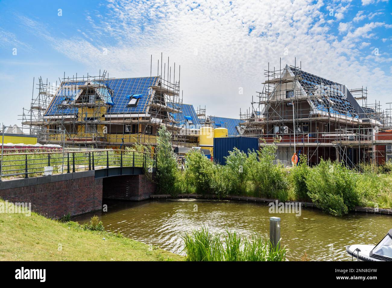Case indipendenti in costruzione in uno sviluppo di alloggi nella campagna dei Paesi Bassi in una giornata di sole estate Foto Stock
